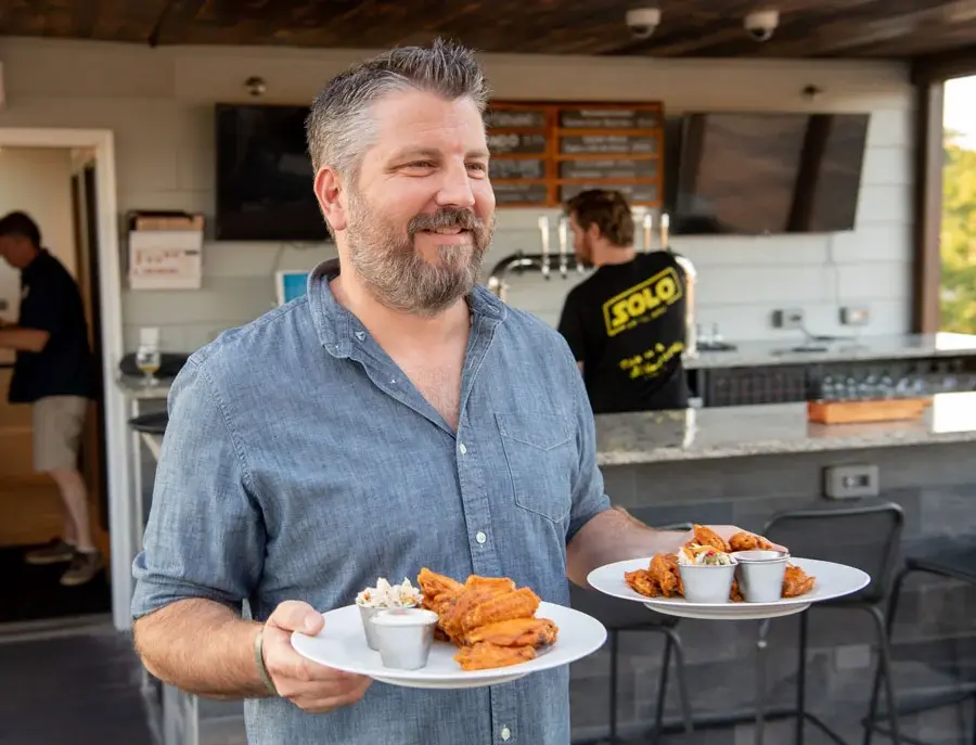 Owner-holding-plates-of-food